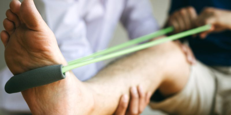 A person does a resistance bar workout as part of corrective exercise. They are stretching that leg out.